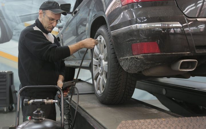 Otomobilin lastik basıncını serviste kontrol eden teknisyen